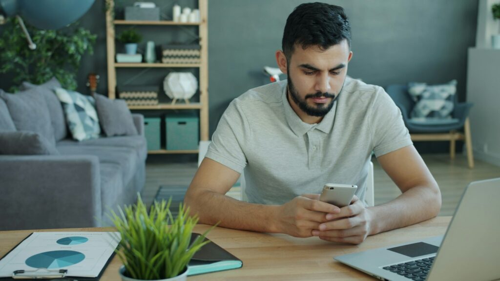 Proprietario controlla sul telefono una recensione negativa Airbnb