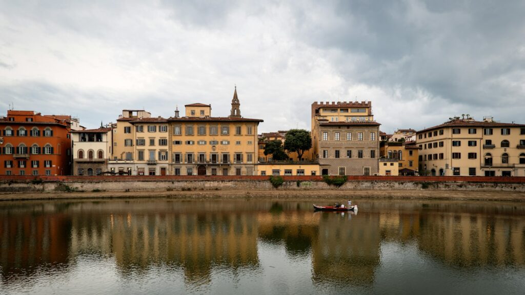 Palazzi sul Lungarno a Firenze riflessi nel fiume Arno, zona di affitti brevi regolamentati